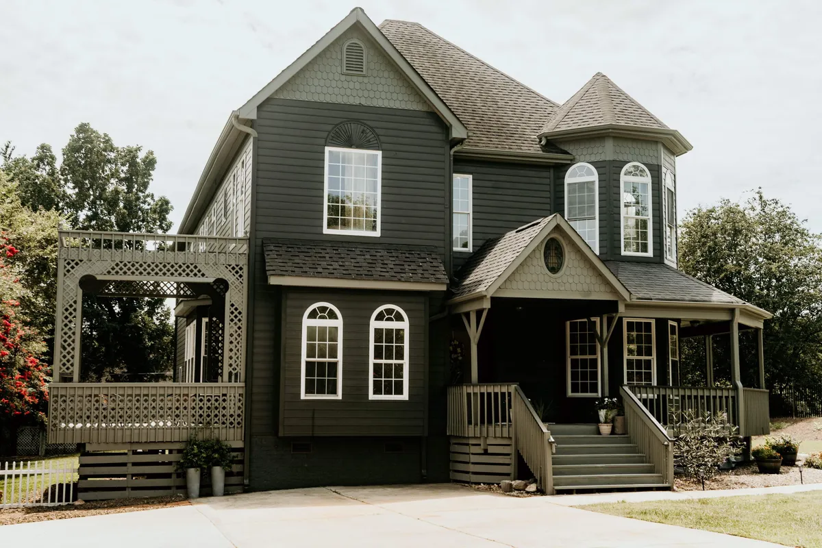 An inviting exterior view of the Victorian home's front porch, featuring large bay windows, a detailed roofline, and charming seating. The scene hints at family gatherings, morning coffees, and a sense of arrival—the perfect launching point for adventures in Mint Hill and beyond.